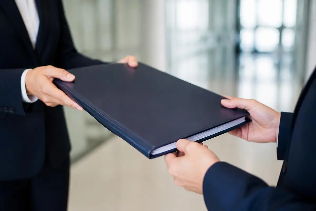 Bound blockchain forensic report in a navy portfolio being handed to legal counsel for filing and evidence disclosure